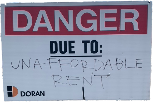 Photo of a Danger due to sign where someone has written unaffordable rent